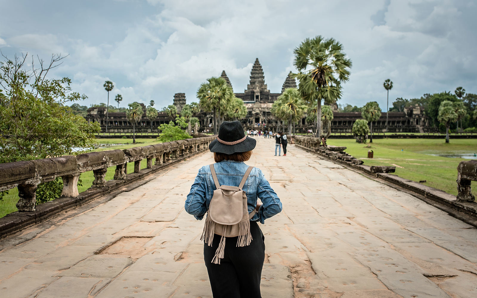 Women tourists wear jacket jeans walking into Angkor Wat landmark in Siem Reap, Cambodia. Angkor Wat inscribed on the UNESCO World Heritage List in 1992