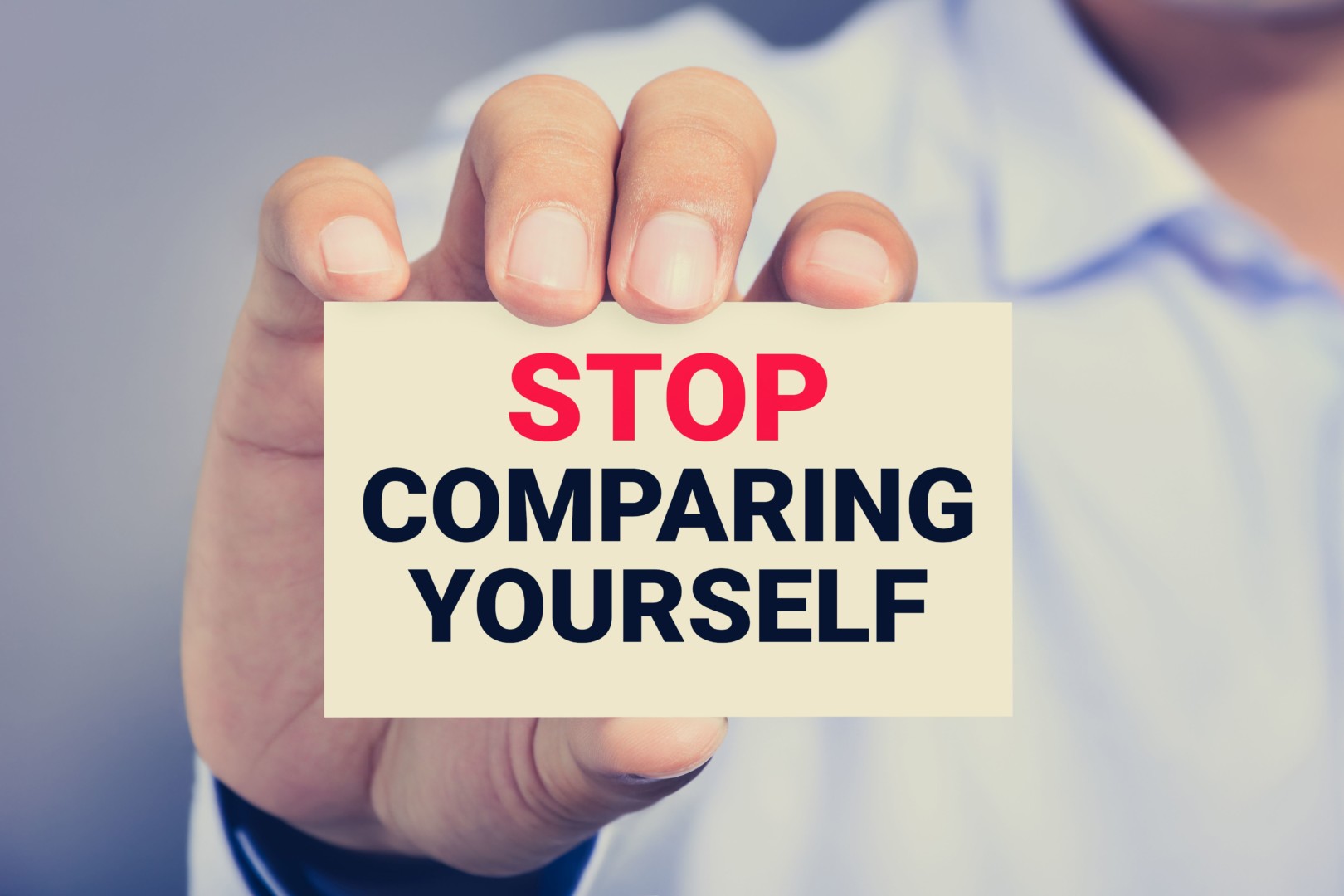 Stop Comparing Yourself, Message On The Card Shown By A Man